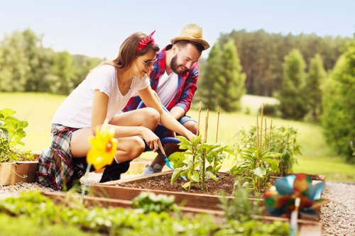 Gardener inspecting a client garden bed