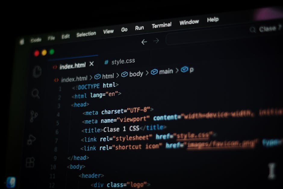 A close-up photograph of a computer screen displaying lines of HTML and CSS code in a dark-themed text editor. The code includes tags such as <html>, <head>, <title>, and <link>, with syntax in variou
